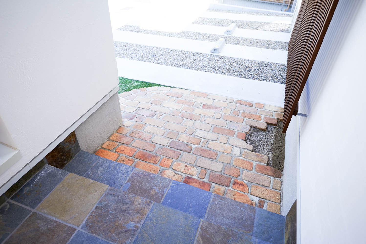 擁壁の上のウッドデッキとシンプルな外構