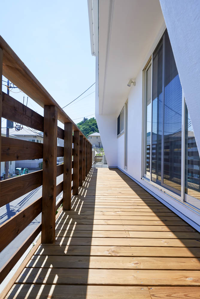 擁壁の上のウッドデッキとシンプルな外構