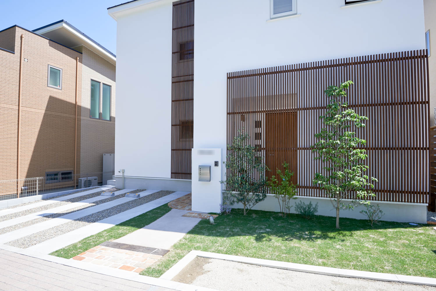 擁壁の上のウッドデッキとシンプルな外構