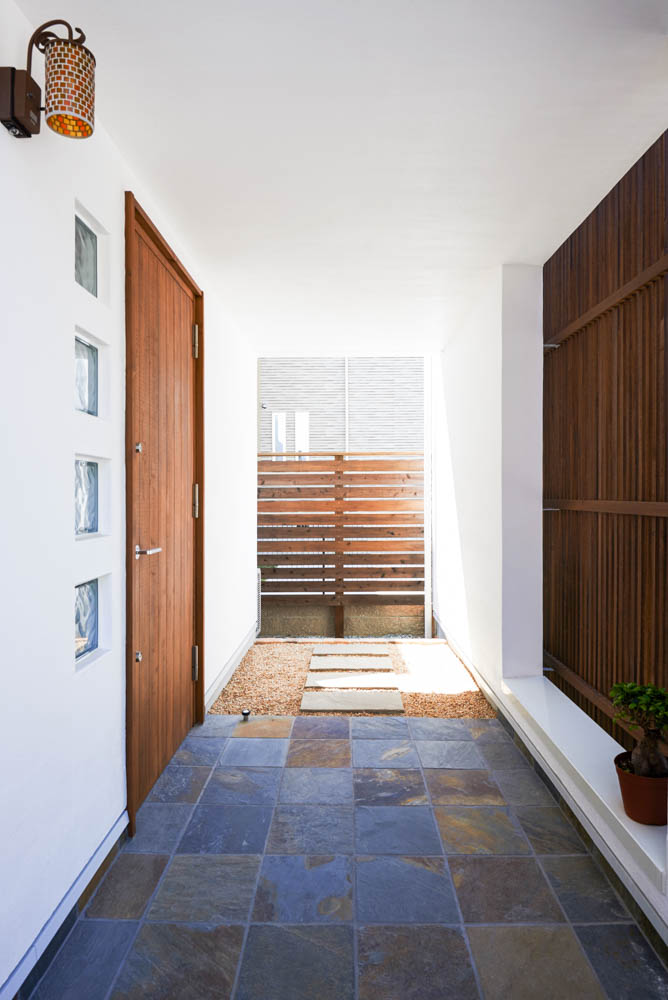 擁壁の上のウッドデッキとシンプルな外構