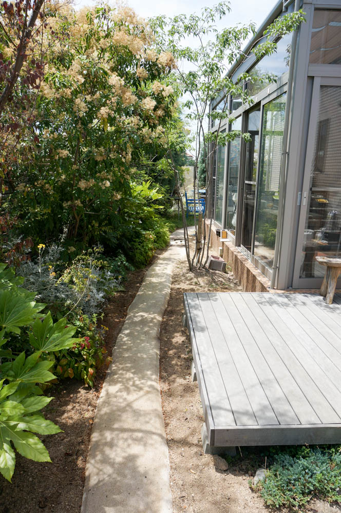木製自転車置き場とミニ菜園と通路