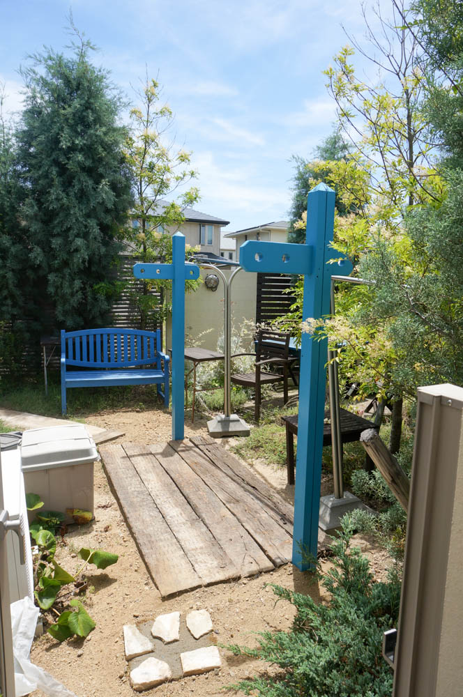 木製自転車置き場とミニ菜園と通路