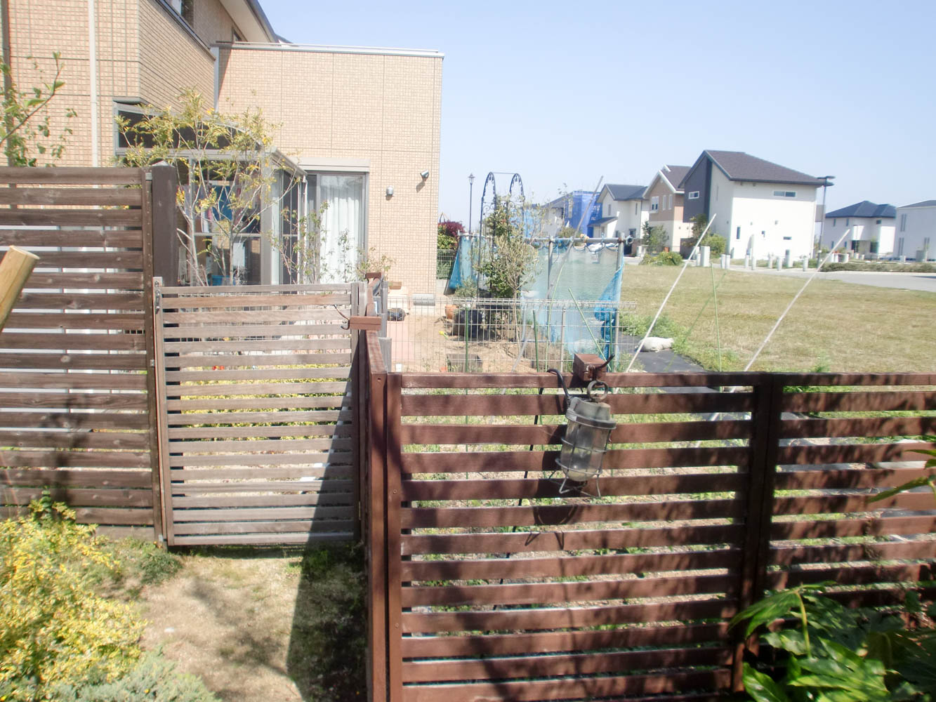 木製自転車置き場とミニ菜園と通路