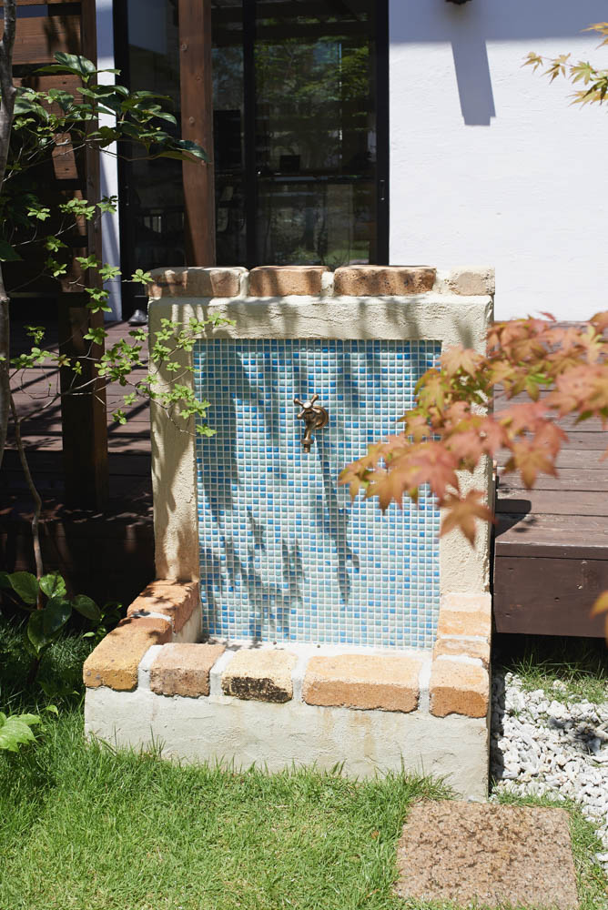 木製自転車小屋とビオトープとオリジナル立水栓のあるショップガーデン