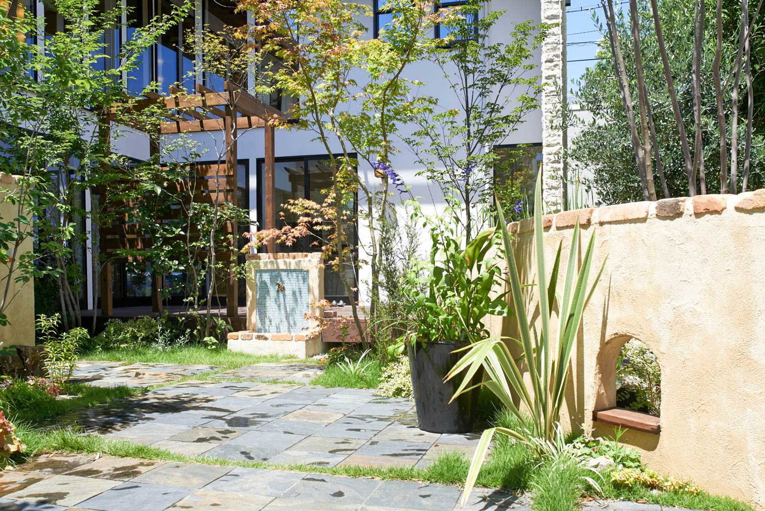 木製自転車小屋とビオトープとオリジナル立水栓のあるショップガーデン