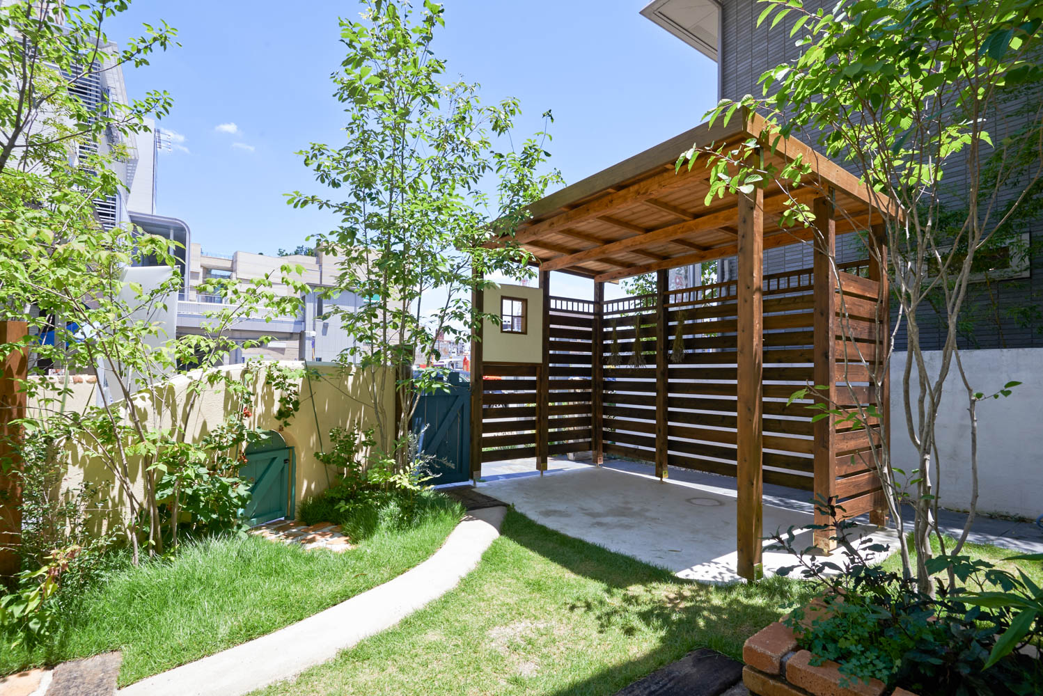 木製自転車小屋とビオトープとオリジナル立水栓のあるショップガーデン